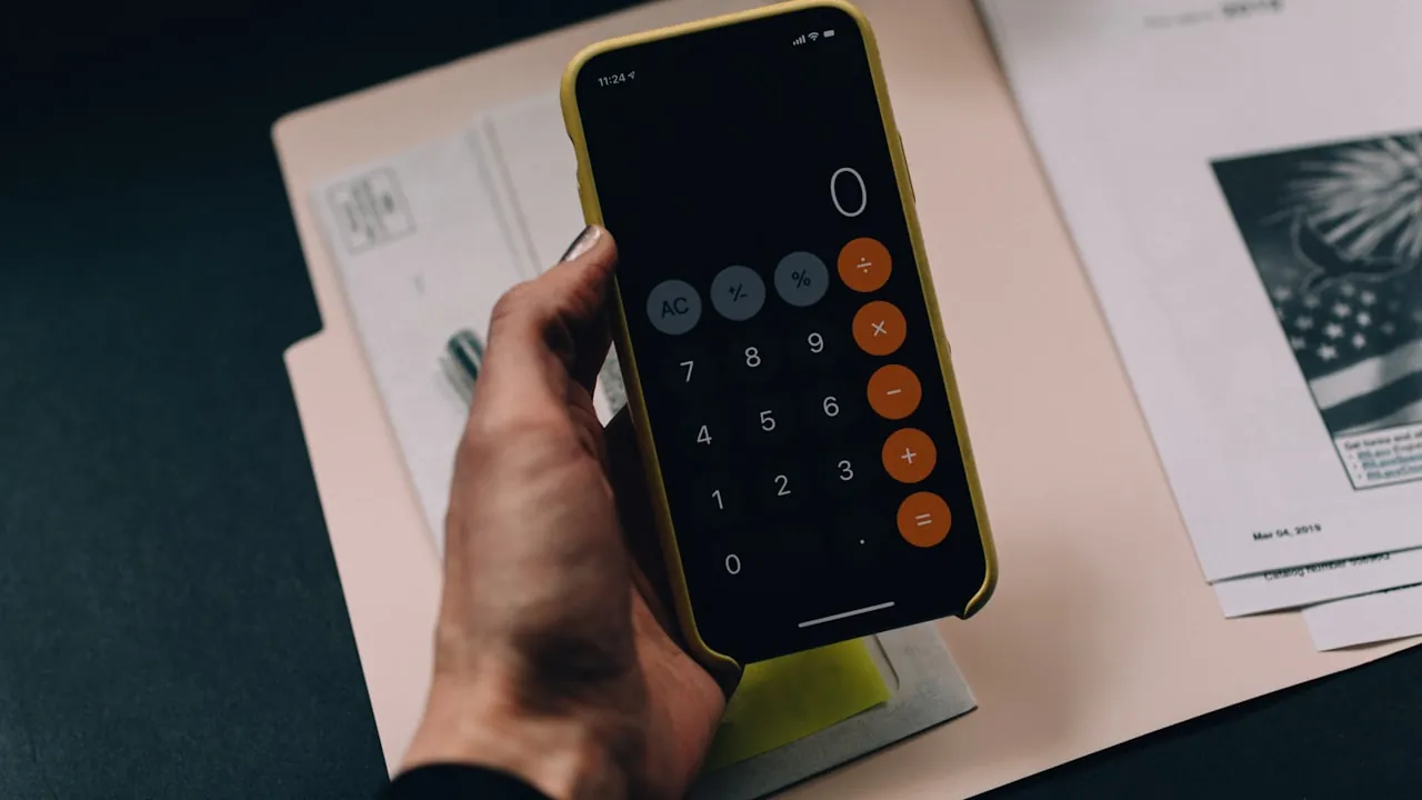 A calculator app open on a phone resting on paperwork, representing website cost